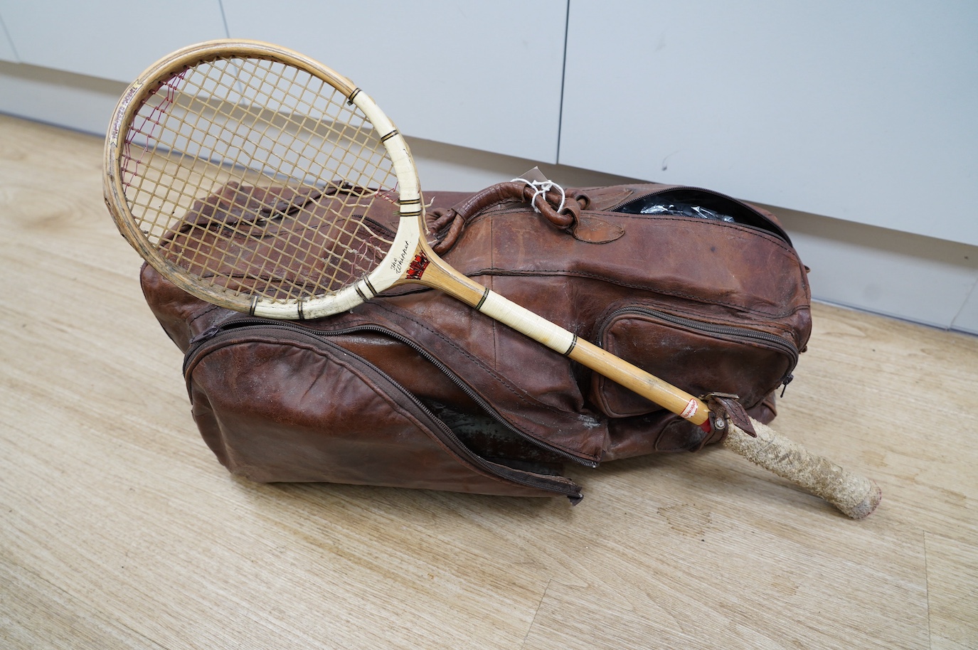 A leather sports holdall, with squash racket. Condition - poor to fair